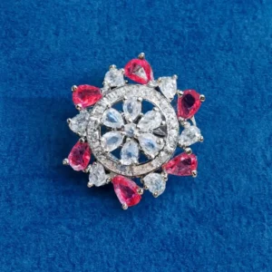 Silver-plated Blushing Stardust Floral CZ Crown Ring by Risha Fine Jewels featuring pink pear-cut petals and sparkling white CZ crystals arranged in a radiant floral halo on a deep blue velvet surface.