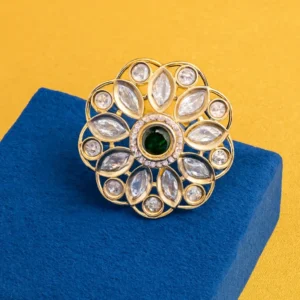 Classic Heritage Emerald Bloom Floral Gold Design Ring with emerald-green centre stone and CZ petal motifs displayed on a blue velvet stand – Risha Fine Jewels.