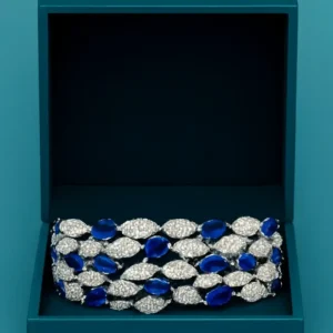 White-gold plated Sapphire Dreamleaf CZ Bracelet for Women featuring marquise blue stones and pave CZ leaf motifs by Risha Fine Jewels.