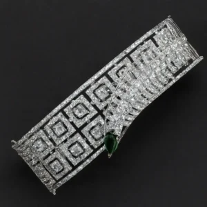 White-gold plated CZ statement bracelet with emerald-green teardrop accent and geometric dual-layer design by Risha Fine Jewels.
