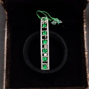 Emerald-green oval-cut CZ designer bracelet in silver finish displayed in a velvet jewelry box by Risha Fine Jewels.