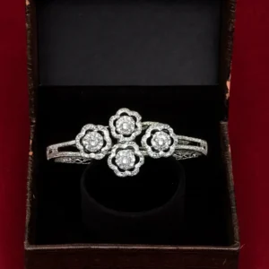 White-gold plated triple-flower CZ bracelet with sparkling cluster motifs displayed in a black velvet jewellery box – Risha Fine Jewels.