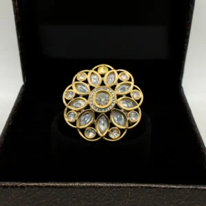 Delicately crafted gold-plated Petal Kiss CZ Flower Ring by Risha Fine Jewels, featuring shimmering marquise petals and a radiant floral sparkle resting gracefully on a blue velvet backdrop.