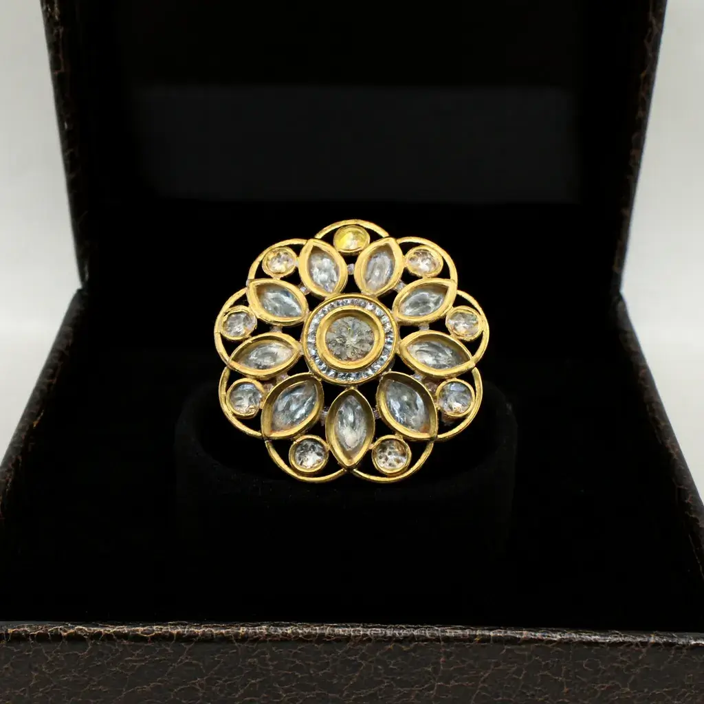 Petal Kiss Marquise-Cut CZ Flower Ring Delicately crafted gold-plated Petal Kiss CZ Flower Ring by Risha Fine Jewels, featuring shimmering marquise petals and a radiant floral sparkle resting gracefully on a blue velvet backdrop.