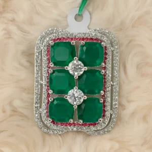 Premium emerald-green stone cocktail ring with square-cut green gemstones and double halo diamond accents by Risha Fine Jewels displayed on soft fur background.