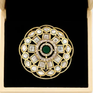 "Royal gold-plated Kundan floral brooch with emerald-green center stone and uncut-style CZs displayed in a jewellery box – Risha Fine Jewels.