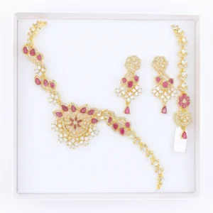 Ruby Pink CZ Floral Necklace Set with Earrings and Maang Tikka – Gold-Plated Bridal Jewelry Featuring Teardrop Ruby Stones, Sparkling CZ Diamonds, and Intricate Floral Detailing by Risha Fine Jewels.