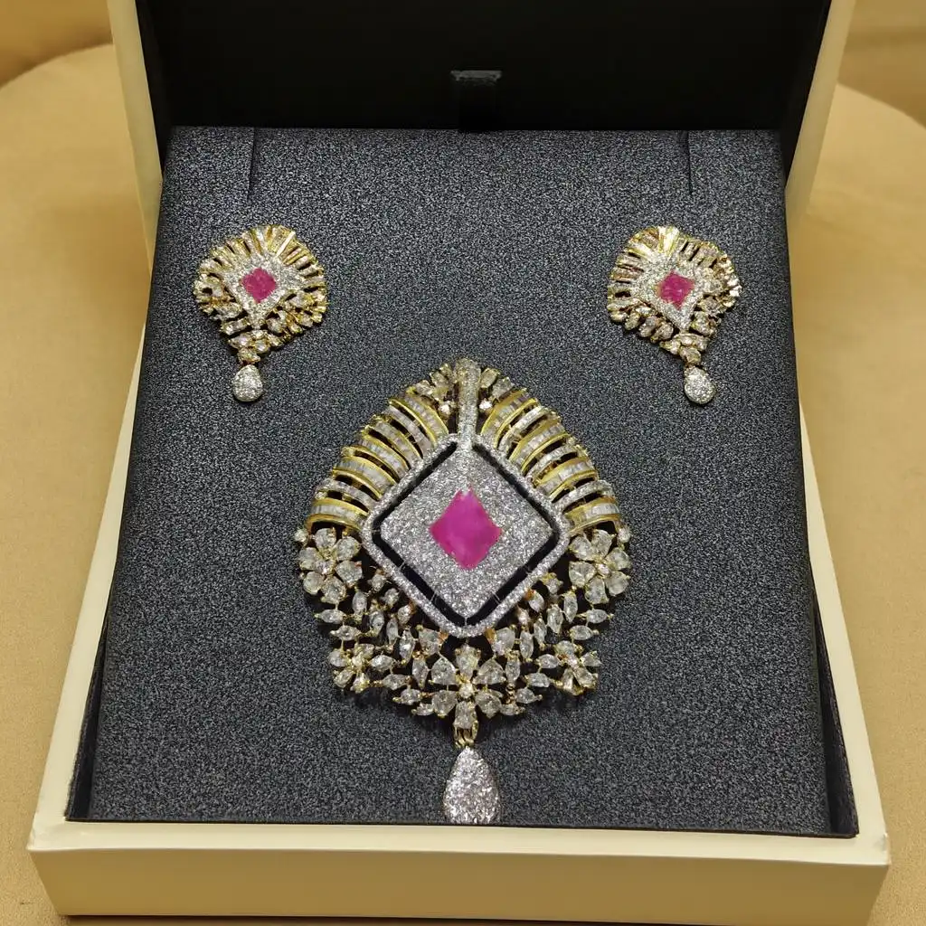 Ruby-Pink Luxe CZ Statement Pendant Set with Earrings – Gold-Plated Glam Jewelry for Celebrations Ruby Pink Luxe CZ Pendant Set with Matching Earrings – Gold-Plated Designer Jewelry Featuring a Square Ruby Centerpiece, Sparkling CZ Diamonds, Floral Detailing & Teardrop Accent by Risha Fine Jewels.