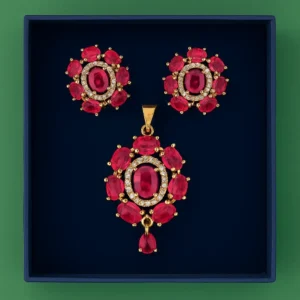Ruby-Red Stone Gold-Plated Pendant Set for Women – Designer Pendant with Matching Earrings Featuring Oval Ruby Stones, CZ Diamond Accents, and Elegant Gold Detailing by Risha Fine Jewels.