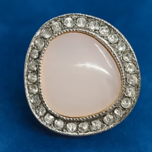 Soft pink cabochon gemstone halo ring with sparkling CZ stones set in a premium silver frame on a blue background